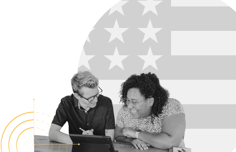 people looking at tablet in front of american flag